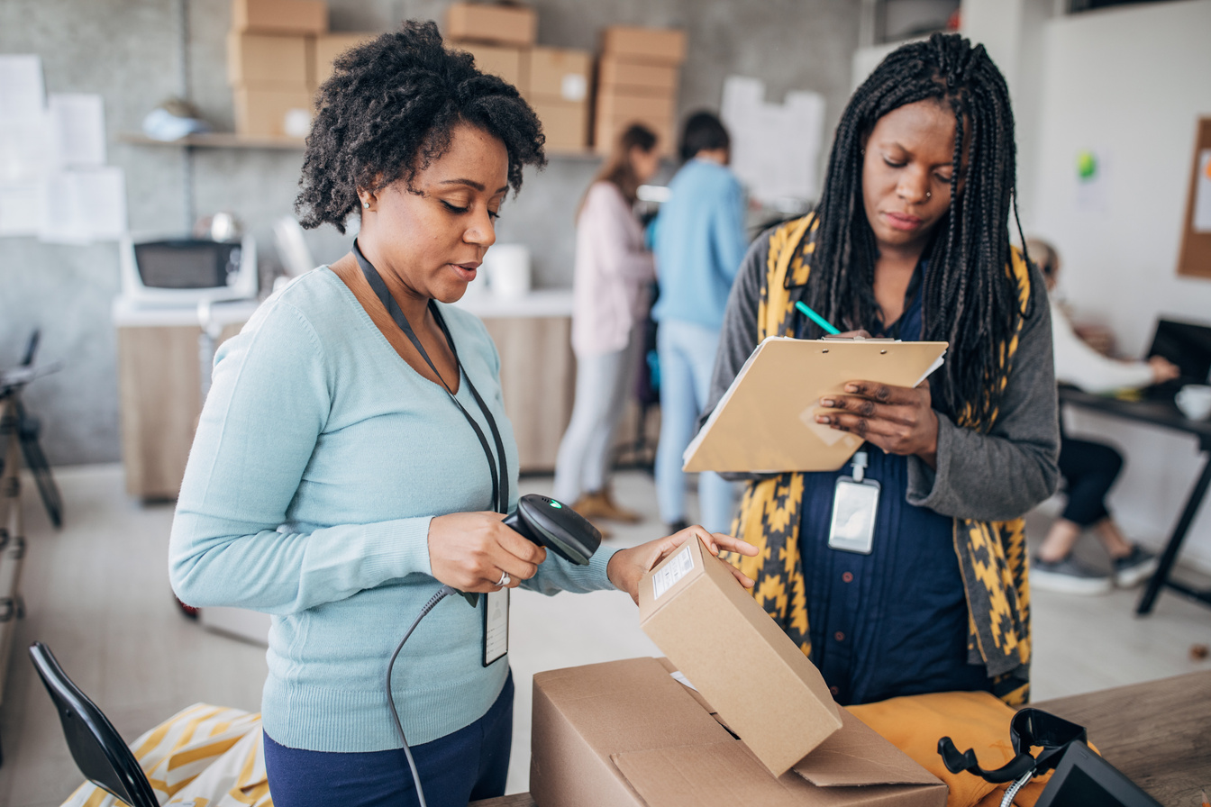 Two black women arranging customers orders for drop shipping